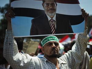 A protester holds a sign of Egyptian president Mohammed Morsi. (Source: AFP)