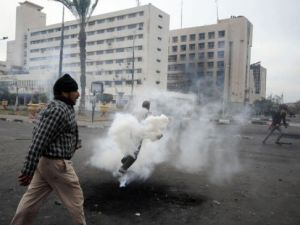 ارشيف/ مصري يمرر امام متظاهر يحاول ابعاد قنبلة غاز باتجاه قوات الشرطة