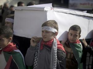 A lack of food and medical supplies is also causing death in Yarmouk. Here, Palestinian children in Gaza stage a fake funeral in solidarity with their brothers in the besieged Damascus camp. (AFP/File)