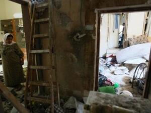 One woman stands in the wreckage of her home in Nablus