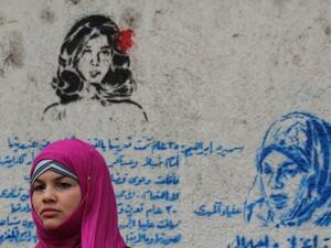 Samira Ibrahim standing next to a graffiti mural that honors her plight. (Image source: "globalpost.com") Samira Ibrahim standing next to a graffiti mural that honors her plight. (Image source: "globalpost.com")