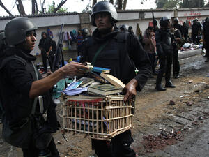 Egyptian police forces remove a crate filled with copies of the Koran and religious books after moving in to disperse supporters of Egypt's ousted president Mohamed Morsi (AFP/MOHAMMED ABDEL MONEIM)