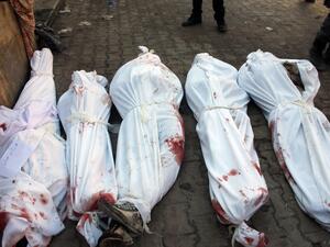 Bodies of victims from an airstrike on the Maadi neighbourhood of the northern Syrian city of Aleppo are seen on the ground wrapped in shrouds on December 17, 2013. This picture was taken on the third day of the bombing campaign - it is now entering its ninth. (AFP)
