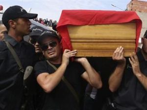 أفراد أمن تونسيون يحملون جثمان أحد زملائهم القتلى الى مقبرة سيدي بوزيد في سيدي بوزيد جنوبي تونس يوم الخميس