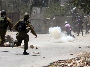 Palestinian demonstrators run for cover during clashes with Israeli troops following a protest against the expropriation of Palestinian land by Israel in the village of Kfar Qaddum near Nablus in the occupied West Bank on August 2, 2013. (AFP)
