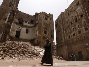 Yemeni man walks past a damaged traditional house in the historical quarter in the Yemeni capital Sanaa on Tuesday. AFP Photo