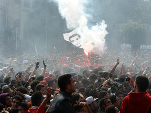 Egyptian fans of Al-Ahly football club wave a flag bearing the portrait of a victim of a football riot as they celebrate outside the club's headquarters in Cairo on Saturday. (AFP)