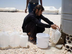 A Syrian refugee in Jordan's Zaatari camp retrieves water. Jordan is one of the most water-scarce countries on earth (File Archive/AFP)
