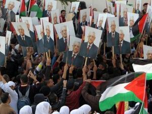 فلسطينيون يرفعون صورا للرئيس الفلسطيني محمود عباس في رام الله
