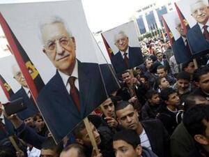 فلسطينيون يحملون صورا للرئيس الفلسطيني محمود عباس في رام الله
