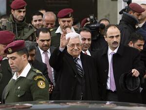 عباس (في الوسط) يلوح عقب حضوره احتفالا في رام الله بالضفة الغربية يوم الثلاثا