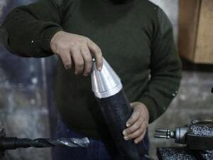 مقاتل يعمل في ورشة لتصنيع قذائف صاروخية في ورشة بحلب
