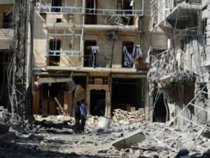 سوريون يتفقدون مبنى تعرض لغارة جوية في حلب
