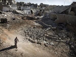A man walks through a destroyed residential area of the Syrian city of Saraqib, southwest of Aleppo, on September 9, 2013, following repeated airstrikes by government forces. The Free Syrian Army have rejected the latest solution to the Syria crisis offered by the US and Russia. (AFP)
