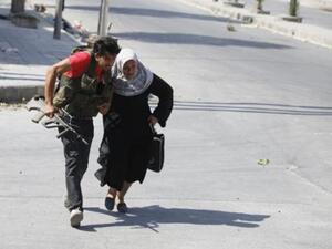 ارشيف/ مقاتل في حلب يساعد امراة على عبور الشارع