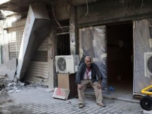 سوري يجلس بعد اصابته قرب مستشفى دار الشفاء في حلب
