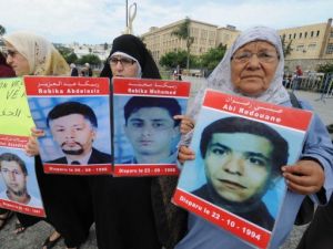 نساء يحملن صور اقاربهن المفقودين في الجزائر