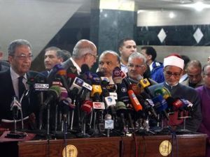 وزير الخارجية المصري الأسبق عمرو موسى يتحدث في مؤتمر صحفي فيما يتحدث محمد البرادعي مع سعد الكتاتني رئيس حزب العرية والعدالة (في المنتصف) في القاهرة 
