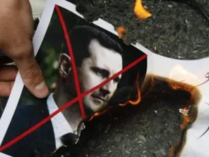 شخص يحرق صورة الاسد خلال مظاهرة امام السفارة السورية في اسطنبول
