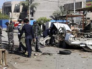 رجال شرطة عراقيون يفحصون حطام سيارة استخدمت في هجوم بقنبلة في مدينة الصدر 