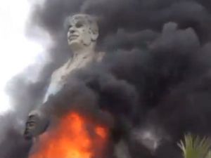 لقطة من فيديو تظهر اضرام النار في تمثال لحافظ الاسد في شركة سد الفرات في مدينة الرقة