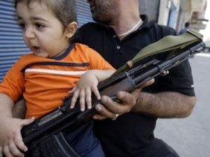 مسلح يحمل طفلا في طرابلس مسلح يحمل طفلا في طرابلس