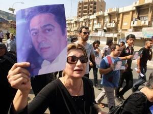 متظاهرون يحملون صور الصحافي هادي الهادي الذي اغتيل في بغداد 