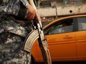 شرطي عراقي يراقب سيارات عند حاجز في بغداد