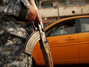 شرطي عراقي يراقب سيارات عند حاجز في بغداد