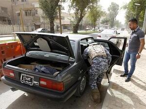 شرطي عراقي يفتش سيارة عند نقطة تفتيش في شارع أبونواس ببغداد
