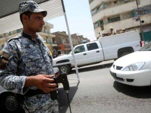 شرطي عراقي يتحقق من عدم وجود عبوات ناسفة عند حاجز في بغداد
