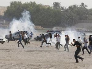 محتجون مناهضون للحكومة يفرون للاحتماء من قنابل غاز خلال مظاهرة شرقي المنامة يوم 15 يونيو حزيران 2012

