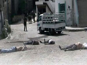 صورة التقطها مواطن صحفي تظهر جنودا من قوات الاسد يقفون قرب جثث قتلى في البيضا
