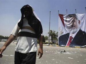 عضو في جماعة الاخوان من أنصار مرسي يمر أمام صورة ضخمة للرئيس المصري المعزول على مقربة من اعتصام رابعة العدوية يوم الأحد
