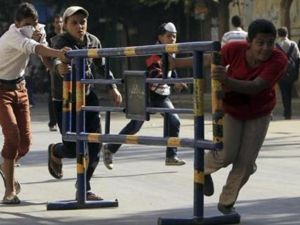 شبان يحركون حواجز خاصة بشرطة المرور أثناء اشتباك بين محتجين والشرطة في شارع محمد محمود قرب مبنى وزارة الداخلية بالقاهرة
