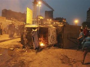 اشخاص يتجمعون بالقرب من حافلة للشرطة بعدما اضرم متظاهرون مناهضون لمرسي النار فيها في ميدان التحرير 
