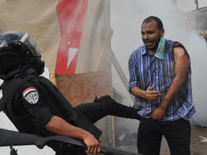 رجل امن يركل احد انصار مرسي خلال فض اعتصام رابعة العدوية