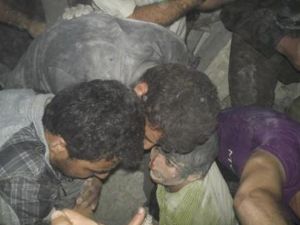 صبي (في الوسط) عقب استخراجه من بين ركام مبنى تهدم في غارة جوية بمنطقة قرب درعا يوم الأحد