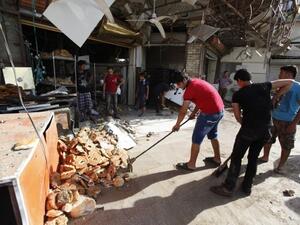 سكان يزيلون حطاما خلفه تفجير في مدينة الصدر في بغداد