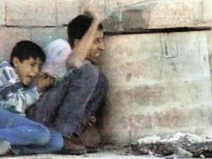 لقطة من الفيديو تظهر الشهيد محمد الدرة بجوار والده اثناء احتمائهما من الرصاص