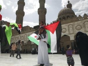 رجل يحمل ابنته وفي يده علمي فلسطين وسوريا داخل الجامع الازهر بالقاهرة
