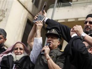 اللواء حسن الرويني يتوسط رجل دين مسيحي ورجل دين مسلم في ميدان التحرير
