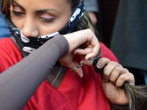 An Egyptian women cutting her hair in protest at the new constitution