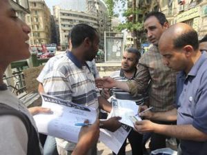 اعضاء من حملة تمرد يجمعون توقيعات مواطنين في ميدان التحرير بوسط القاهرة
