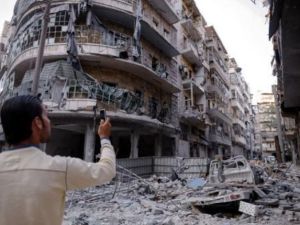 رجل يلتقط صورا بهاتفه النقال للدمار في حي طريق الباب في حلب بشمال سوريا
