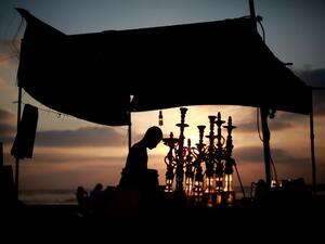 A man readies water pipes as the sun sets over the Gaza Strip during Ramadan. (AFP / Mohammed Abed)