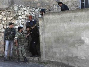 جنود من الجيش السوري الحر يأسرون رجلا يشتبهون في انتمائه لقوات الاسد في بلدة حارم
