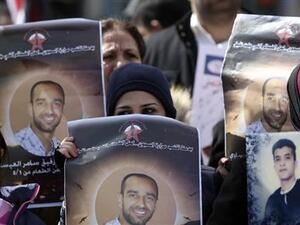 فلسطينيون يرفعون صورا للعيساوي الاسير الفلسطيني المضرب عن الطعام
