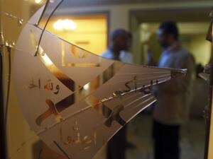 عضوان في الاخوان يبدوان خلف البوابة المحطمة لمقر الجماعة في القاهرة