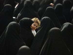 An Iranian woman carries her child. (UPI File Photo/Mohammad Kheirkhah) 